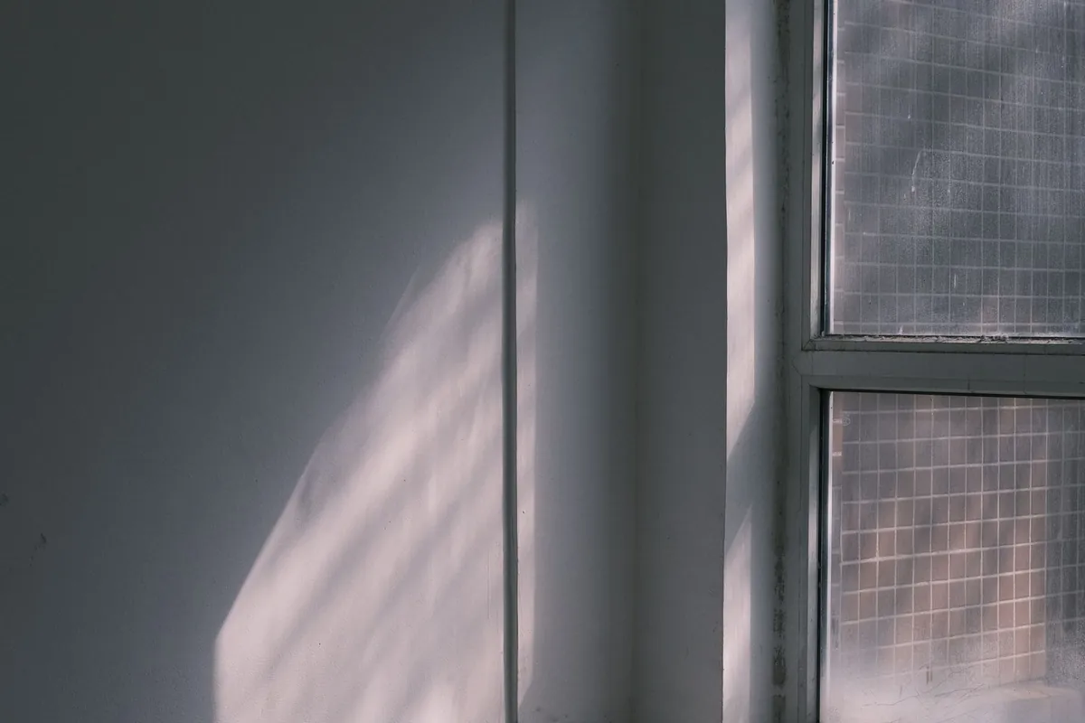 Calm empty white room with soft sunlight on the window frame